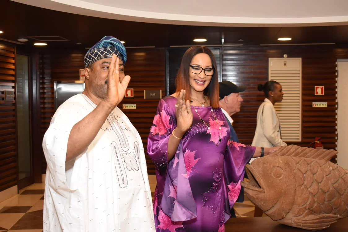 Two guests waving during their arrival at the community reception