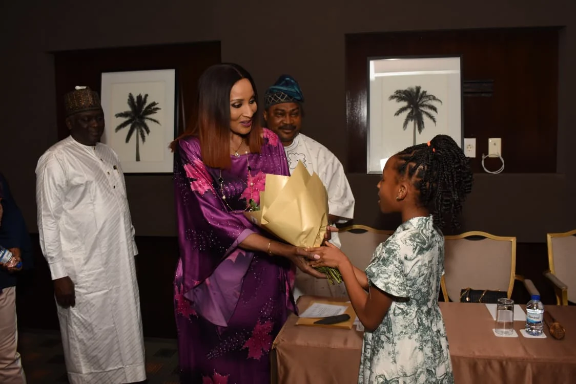 A young girl presenting a bouquet to the visiting guest