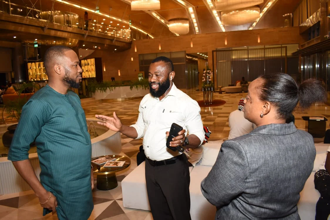 Three community members speaking together in the hotel lobby